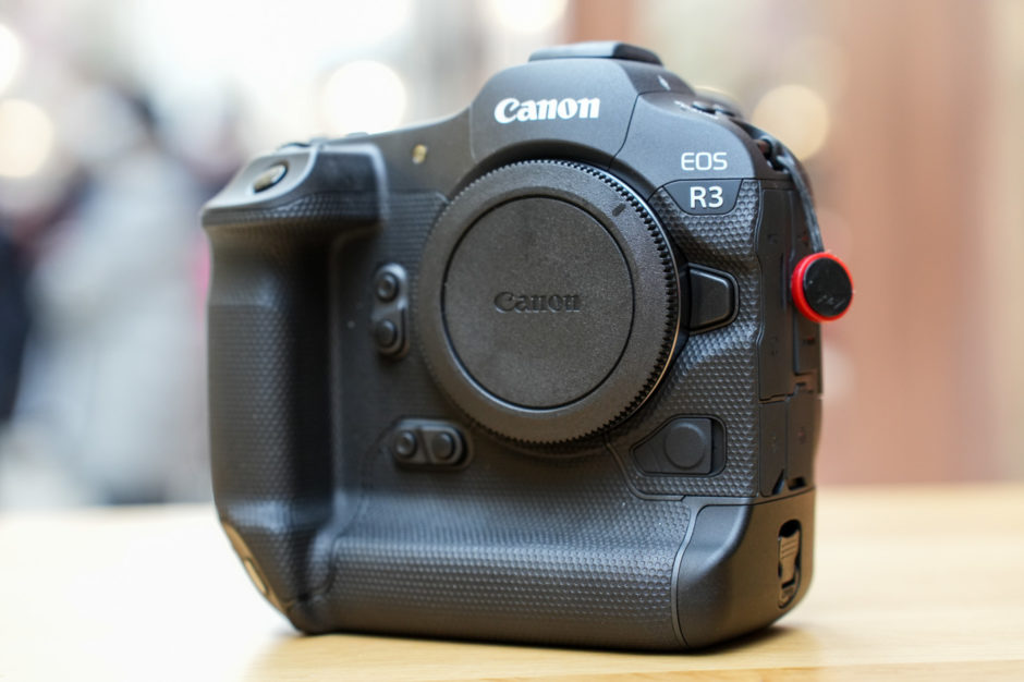 Photographe professionnel tenant le Canon EOS R3 sur un événement sportif, symbole de performance, vitesse et précision pour le photojournalisme d’action.