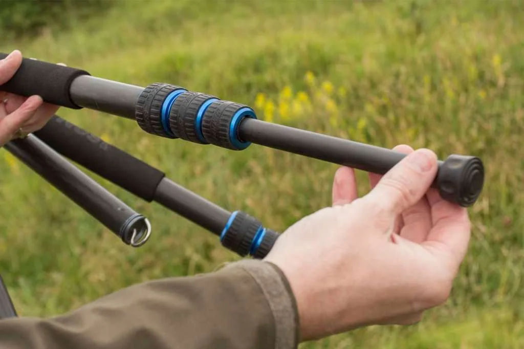 Déploiement des sections supérieures d'un trépied photo pour garantir la rigidité de la structure.