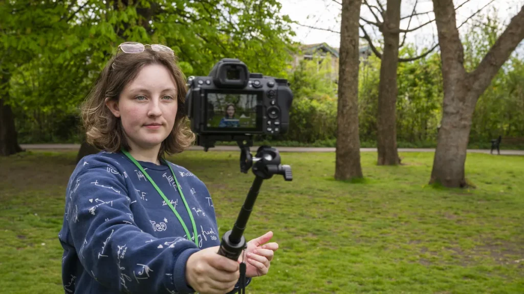 Femme avec appareil photo sur une perche Neewer minindans parc