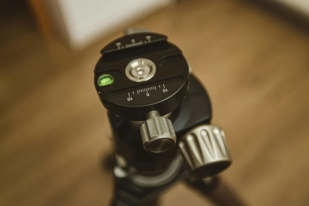 Gros plan d'une rotule ball de précision montée sur un trépied photo pour illustrer la stabilité du matériel professionnel.