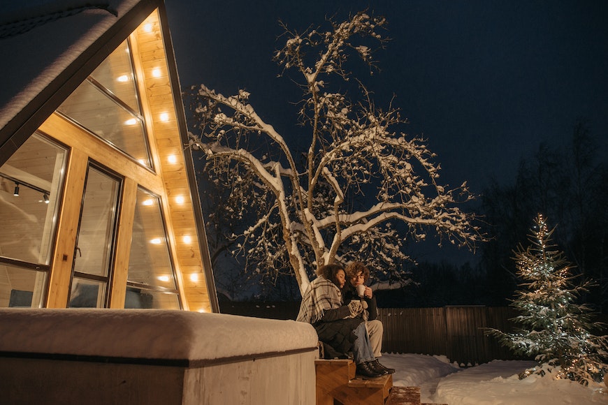 couple assi devant une maison lumineuse