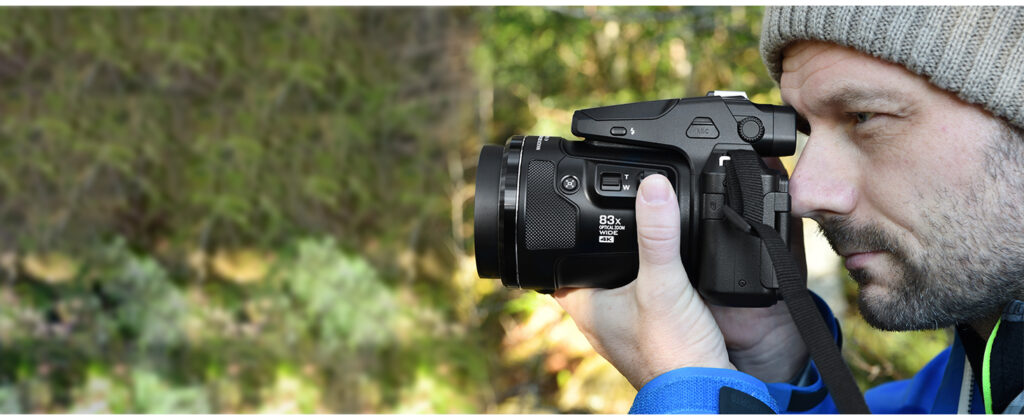 Photographe amateur explorant la nature avec un bridge Nikon Coolpix P950