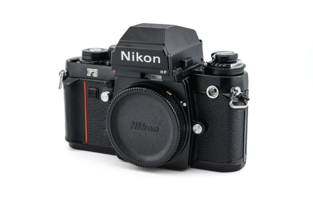 Nikon F3 posé sur un carnet de voyage – Appareil photo reflex argentique professionnel mythique.