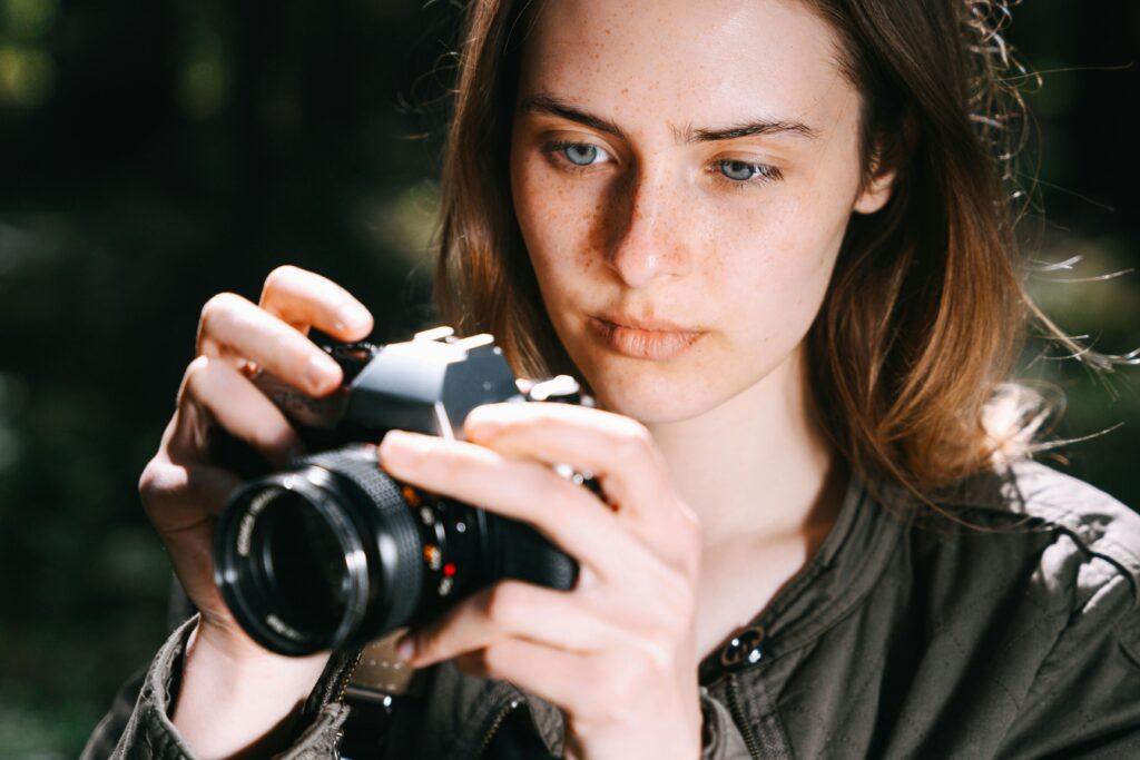 Photographe tenant un appareil photo hybride léger – idéal pour voyager et créer en toute liberté