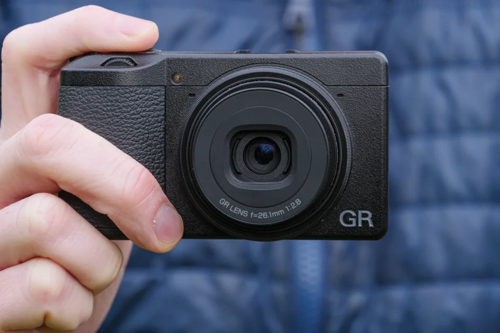 Ricoh GR IIIxtenu en main – appareil photo de rue minimaliste